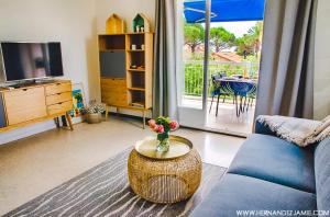 - un salon avec un canapé et une table fleurie dans l'établissement Relax&co - parking gratuit - wifi - terasse - mer, à Saint-Cyr-sur-Mer