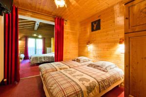 ein Schlafzimmer mit einem Bett in einem Blockhaus in der Unterkunft Hôtel Le Kandahar in Châtel