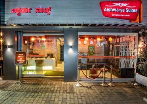 a restaurant with a sign on the front of it at Aishwarya Suites in Mysore