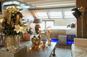 una camera con un letto e un tavolo con fiori e candele di Suite & B by Hofke van Bazel a Bazel