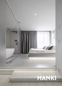 a white bedroom with a bed and a bath tub at HAAWE 1933 - Boutique Apart Hotel in Rovaniemi