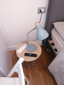 a small table with a lamp on it next to a bed at Welcome Home in Milan