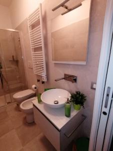 La salle de bains est pourvue d'un lavabo et de toilettes. dans l'établissement Welcome Home, à Milan