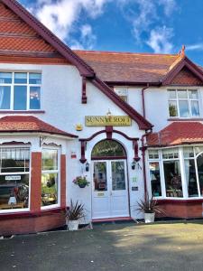 un edificio con un cartel en la parte delantera en Sunnycroft Private Hotel en Llandudno