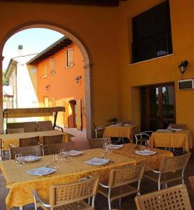 a dining room with a table and chairs and a building at Agriturismo Bortolino in Volta Mantovana