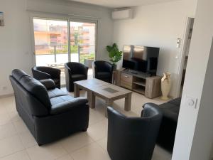 a living room with chairs and a table and a television at Appartement 4 chambres LE BAIA in Sainte-Maxime