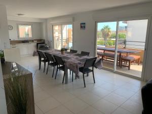 a dining room with a table and chairs and a kitchen at Appartement 4 chambres LE BAIA in Sainte-Maxime