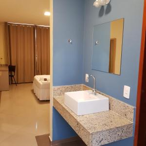 y baño con lavabo blanco y espejo. en Paracambi Top Hotel, en Paracambi