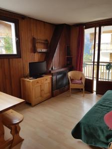 a bedroom with a bed and a television and a table at Le Petit Chalet in Auron