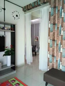 ein Wohnzimmer mit einer Kachelwand und einem Wohnzimmer in der Unterkunft Teratak Delisha -musslim in Kampong Jemampar