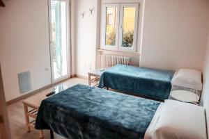 Habitación hospitalaria con 2 camas y 2 ventanas en AFFITTACAMERE TORRESI 2, en Ancona