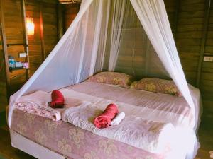 two dolls laying on a bed in a room at Tha Khao Bay View in Ko Yao Noi