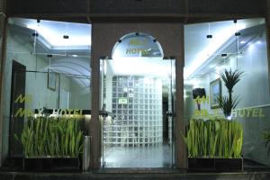 a hotel lobby with plants in front of a door at Max Hotel in Brasilia