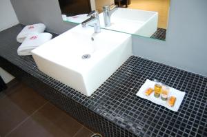 baño con lavabo blanco y encimera de azulejos negros en Hotel Dulce Boca en Veracruz