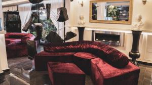 a living room with a red ottoman and a mirror at Meeting Hotel in Casoria