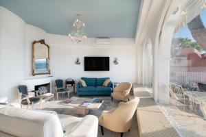 sala de estar con sofá azul y sillas en Château des Anglais - Five Stars Holiday House, en Niza