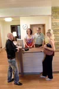 a group of people standing around a reception counter at Hotel - Restaurant Baumann in Freiberg am Neckar