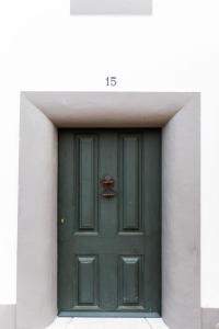 a green door in a white building at Casa do Xão in Serpa