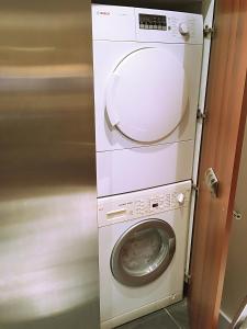 a washing machine with its door open next to a washer at 2 Bed Luxury apartment in Bayswater - amazing terrace views from 7th floor in London