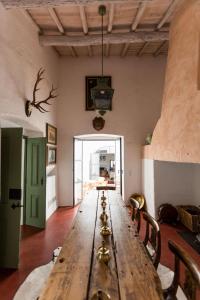 a long wooden table with chairs in a room at Casa do Xão in Serpa