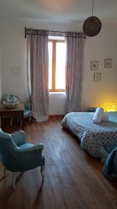 1 dormitorio con cama, ventana y silla en les Croses petites, en Revel