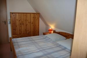 Ferienwohnung Kinnerstuw في بريرو: غرفة نوم صغيرة مع سرير وخزانة خشبية