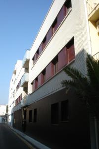 biały budynek z czerwonymi oknami na ulicy w obiekcie Sun d'Aro w mieście Platja  d'Aro