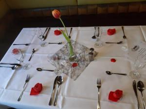 einen weißen Tisch mit einer Vase mit einer Blume darin in der Unterkunft Hotel-Restaurant Johanneshof in Nentershausen