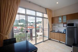 a kitchen with a large window and a dining room table at U Sabai Living Hotel - SHA Certified in Patong Beach