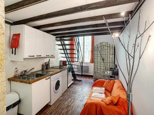 een keuken met een oranje bank in een kamer bij La Maison de Sebea in Bordeaux