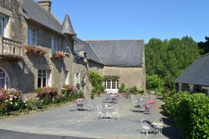 a courtyard with tables and chairs in front of a building at Hostellerie de la Motte jean in Saint-Coulomb