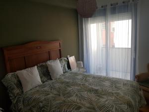 un letto in una camera da letto con una grande finestra di Calma House a Saragozza