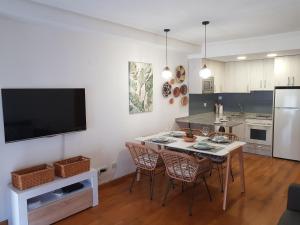 una cucina e una sala da pranzo con tavolo e sedie di Calma House a Saragozza