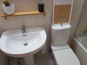 un bagno con un lavandino bianco e un water di Calma House a Saragozza Altre 21 foto
