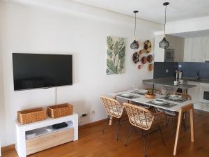 una cucina con tavolo, sedie e TV di Calma House a Saragozza