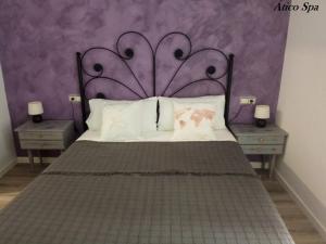 a bedroom with a large bed with a purple wall at Casas Toya Jacuzzi in Uceda