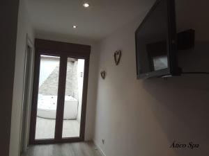 a room with a sliding glass door and a television at Casas Toya Jacuzzi in Uceda
