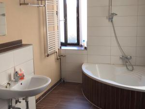 ein Badezimmer mit Badewanne und Waschbecken in der Unterkunft Hotel Einstein in Bad Krozingen