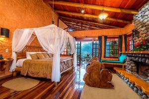 a bedroom with a canopy bed and a fireplace at Peace Lodge in Vara Blanca