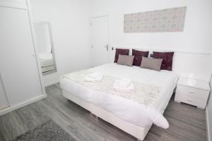 a bedroom with a white bed with two towels on it at Grannies House in Machico