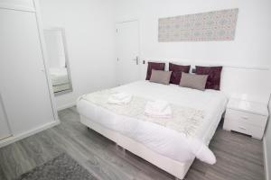 Un dormitorio con una cama blanca con dos toallas encima. en Grannies House, en Machico