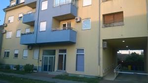 ein Apartmenthaus mit einer Tür und einem Balkon in der Unterkunft Apartman Mario in Osijek