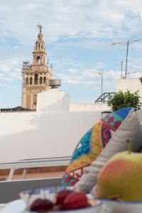 - une vue sur une tour d'horloge depuis le sommet d'un bâtiment dans l'établissement Céntriko Apartments Quintero 40, à Séville