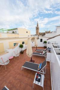 - un balcon avec des chaises et des parasols dans un bâtiment dans l'établissement Céntriko Apartments Quintero 40, à Séville