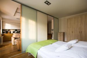 1 dormitorio con 1 cama blanca grande y cocina en Apartamenty w Villa Park, en Ełk