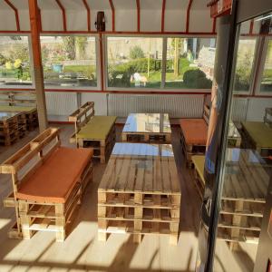 a room with tables and benches and windows at Teo's Guest House in Dospat