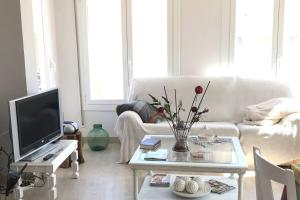 a living room with a white couch and a tv at Casa Maria Dolors con piscina y jardin privado in Puig-Gros