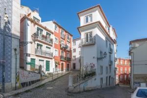 eine Straße in einer Altstadt mit bunten Gebäuden in der Unterkunft Light Filled Typical Apartment at Alfama, By TimeCooler in Lissabon