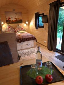 a room with a bed and a table with two glasses and a bottle at Rhön Lodge in Poppenhausen