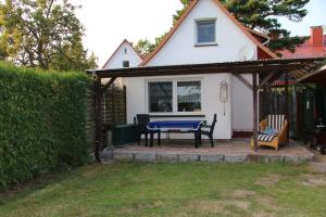 Ferienwohnung Wiesenblick في بريرو: فناء مع طاولة وكراسي أمام المنزل +صورتان